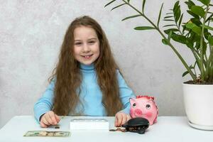 linda sonriente niña sentado a el mesa cuenta dinero utilizando un calculadora desde un cerdito banco y un billetera, financiero literatura foto