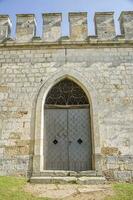 Old castle stone wall with closed big metal doors. Vintage gates. photo