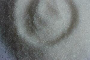 sugar in a green plastic cap on a white background close up photo