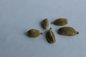 Cardamom seeds isolated on white background. Cardamom is a genus of herbaceous flowering plants in the family Cardamom. photo