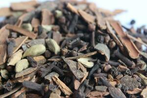 seco especias en blanco antecedentes. cerca arriba de un mezcla de té hojas y especias foto