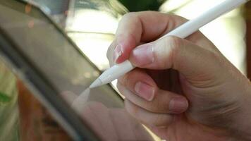 Close-up view of hand using digital stylus writing on tablet. concept of digital signature Electronic document signing via digital tablet or app design video