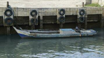 A small wooden fishing boat docking at the harbor. photo