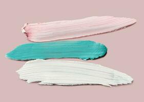 Samples of color correcting concealers Set on pink background. Swatch smears of cream makeup base photo