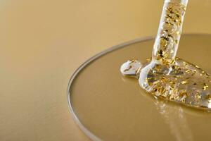 pipeta y gel cosmético productos con oro en un petri plato en beige antecedentes foto