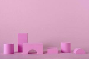 Abstract pink background with different shape podiums for products presentation or exhibitions. Geometric composition with copy space photo