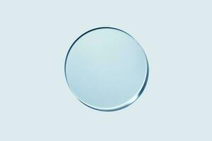 Empty round petri dish or glass slide on blue background. Mockup for cosmetic or scientific product sample photo