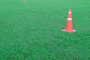 Traffic cone or funnel on green field background. photo