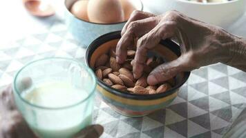 Close up senior woman hand holding a bowl on almond video