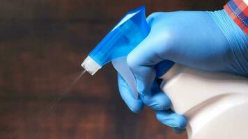 hand in blue rubber gloves holding spray bottle and wiping flat surface video