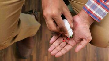 La mano del hombre con la medicina derramada fuera del contenedor de pastillas video