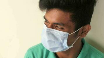 Close up of man with protective face mask looking at camera video