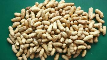 Falling processed pea nuts in a bowl on table top down video