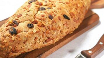 Baked brow bread on chopping board on table , video