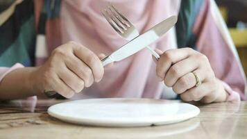 Woman hand holding cutlery with empty plate waiting for food video