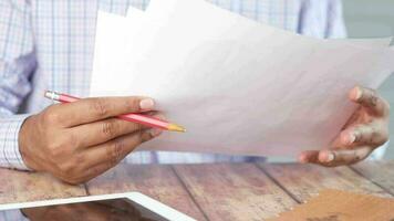 Mano de hombre con lápiz analizando gráfico de barras en papel video