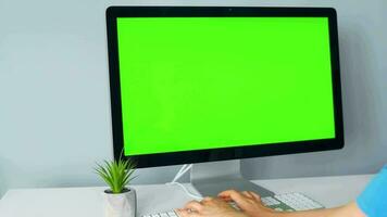 Woman typing on a computer keyboard at home office, monitor with a green screen. Chroma key. Copy Space. Concept of remote work. video