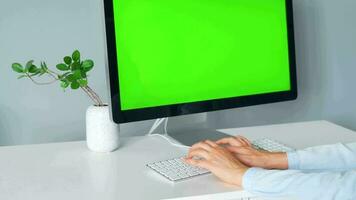 femme dactylographie sur une ordinateur clavier à Accueil bureau, moniteur avec une vert filtrer. chrominance clé. copie espace. concept de éloigné travail. video