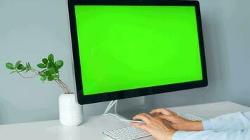 Woman typing on a computer keyboard at home office, monitor with a green screen. Chroma key. Copy Space. Concept of remote work. video