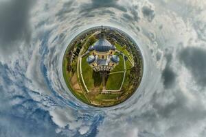 pequeño planeta transformación de esférico panorama 360 grados con vista a Iglesia en centrar de globo en azul cielo. esférico resumen aéreo ver con curvatura de espacio. foto