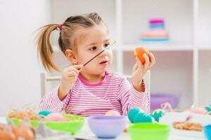 A young girl painting Easter eggs photo