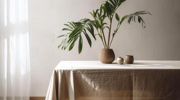 Touchy beige cotton tablecloth on counter table, tropical dracaena tree in daylight on white divider foundation. photo