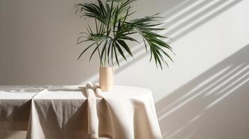 Obliged beige cotton tablecloth on counter table, tropical dracaena tree in sunshine on white divider establishment. photo