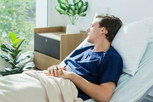 the doctor is examining the patient in the hospital. Caucasian female doctor talking to male patient lying in hospital bed. photo