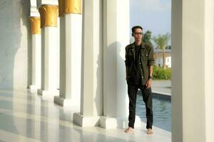 a man posing between the pillars of the beautiful mosque, at the Great Mosque of Sheikh Zayed Solo photo