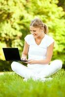 Woman with laptop working outside photo