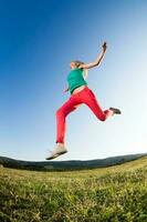 Woman jumping outdoors photo