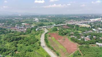 4K footage aerial view of the highway between greenery and residential areas. video