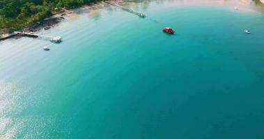 Antenne Drohne Aussicht von das tropisch Strand mit klar Türkis Meer, Weiß Sand und Palme Baum video