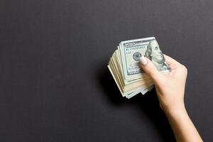 Top view of female hand holding a pack of money on colorful background. Various dollars. Business concept with empty space for your design. Charity and tips concept photo