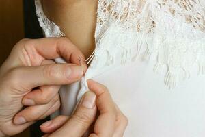 Female seamstress prepares dress to the fitting. Close up photo