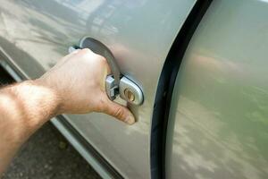 Hand on handle. Close-up of man hand opening a car door. photo