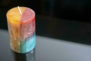 aromatic colored decorative candle on a dark background, aromatherapy photo