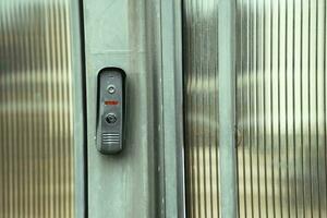 intercom panel with a video camera on the brick fence of private house photo