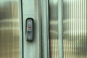 intercom panel with a video camera on the brick fence of private house photo