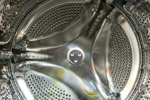 shiny drum of the front washing machine inside, household appliances photo