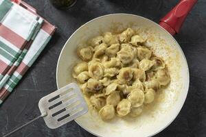 delicious golden fried ravioli in a frying pan on the table. Fried dumplings for dinner photo