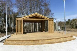 wooden gazebo stage built in a city park. a platform for performances photo