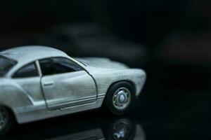 a model of an old classic shabby car on a glossy black glass background photo