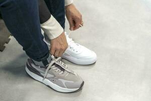 a girl tries on new sneakers in a sportswear store photo