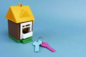 house model and keys on a blue background. Purchase of real estate photo