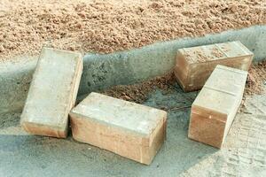 paving slabs lie prepared for laying near curb on construction site photo