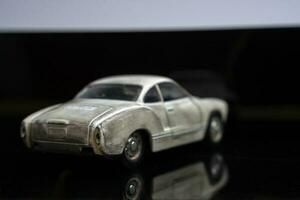 un modelo de un antiguo clásico desgastado coche en lustroso negro vaso. de cerca foto