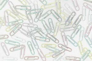 Cheerful background of colored paper clips on a white background photo