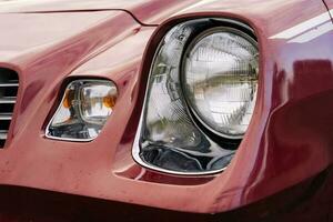 front headlight is a close-up of an old powerful classic American car photo