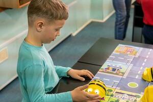 a European preschooler boy at a robotics lesson for children photo